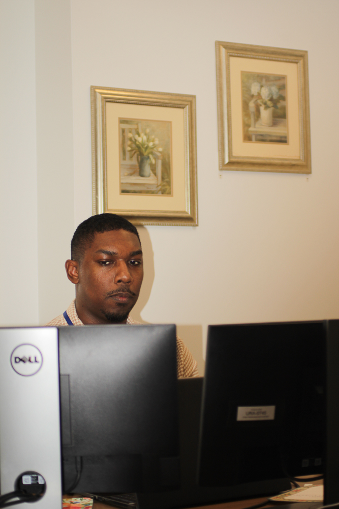 Marcus Robinson works at his desk in a dramatic portrait.